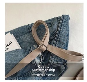 Macro view of blue denim crossbody bag featuring durable strap and metal buckle details