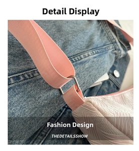 Detail of pink fabric shoulder strap and silver metal ring on textured crossbody bag
