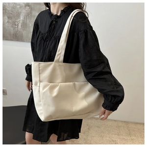Vue détaillée du grand sac fourre-tout en toile avec une poche avant plissée élégante