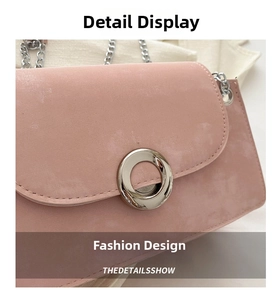Gros plan du sac en daim rose avec boucle anneau argentée et détail de bandoulière