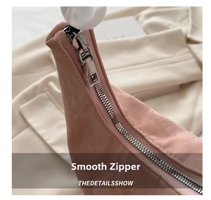 Detail view of the high-quality silver metal zipper on a pink pleated shoulder bag