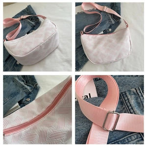 Detail view of pink and white textured jacquard crescent bag with adjustable strap
