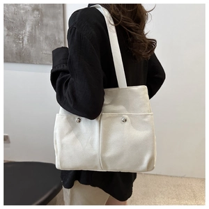 Détail du sac fourre-tout en toile blanc cassé avec doubles poches et fermoirs magnétiques
