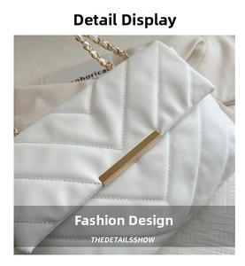 Detail of white quilted crossbody bag featuring V-shaped stitching and gold chain strap