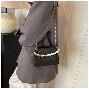 Détail du petit sac crocodile avec poignée en perles et cœur et fine bandoulière dorée