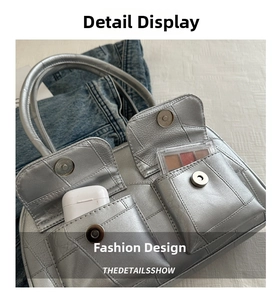 Detailansicht einer silbernen Tasche mit funktionaler Magnetklappentasche und Fächern