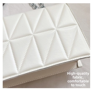 Détail du sac en similicuir blanc avec matelassage triangulaire et chaîne argentée
