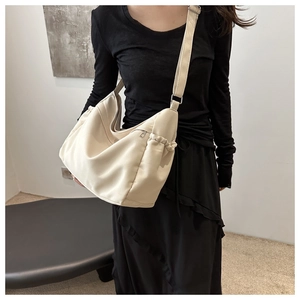 Detail of adjustable strap and drawstring side pocket on the beige canvas tote bag