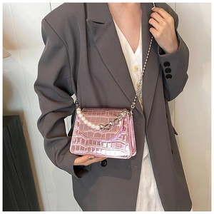 Detail of pink metallic mini flap bag with crocodile pattern and pearl chain handle