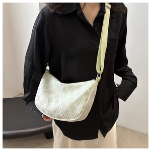 Detail view of mint green canvas crossbody bag with textured fabric and adjustable strap