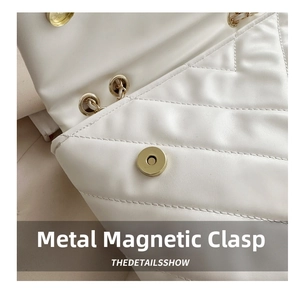 Macro shot of white quilted leather bag featuring a durable gold magnetic snap closure