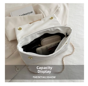 Interior view of white quilted shoulder bag showing space for phone and wallet