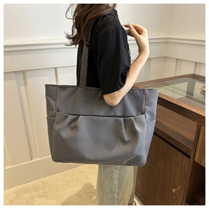 Vue latérale d'un grand sac cabas gris foncé plissé porté à l'épaule par un mannequin