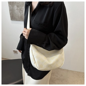 Detail of beige nylon hobo bag with geometric woven texture and fabric shoulder strap