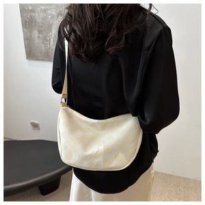 Detail of cream woven nylon dumpling bag with textured crescent shape and strap