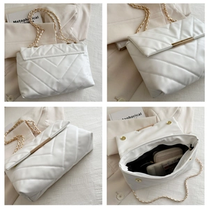 Detail showing white V-quilted faux leather bag with gold chain strap and internal space