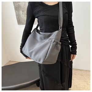 Detail view of large grey nylon tote bag with wide strap and silver metal buckle