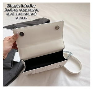 Vue intérieure d'un sac à chaîne blanc matelassé avec compartiment et fermoir aimanté