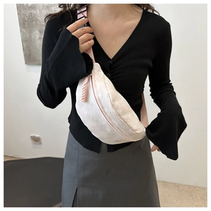 Detail of cream textured fabric crossbody bag with adjustable pink shoulder strap