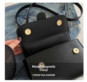 Dettaglio delle doppie fibbie magnetiche dorate su borsa a tracolla in ecopelle nera