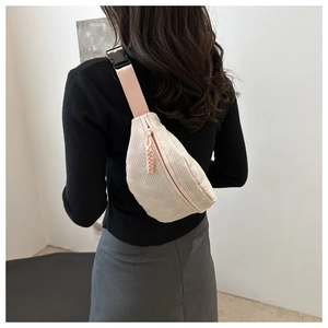 Detail of light pink crossbody bag showing geometric texture and adjustable strap buckle