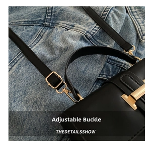 Dettaglio della fibbia regolabile in metallo dorato sulla tracolla in pelle nera su denim