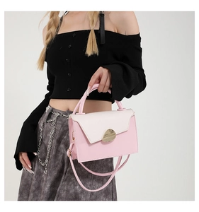Détail du sac à main bicolore rose et crème avec fermoir géométrique doré élégant