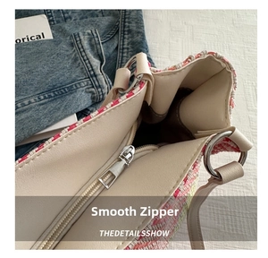 Detailed macro view of smooth silver zipper and colorful woven texture on the tote bag