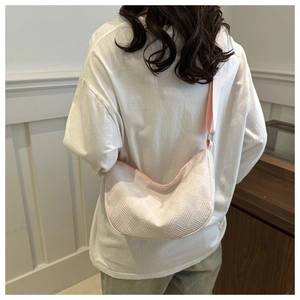 Detail of white and pink woven semi-circle tote bag with 3D geometric texture strap