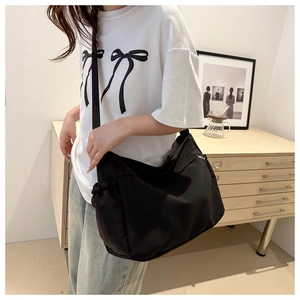 Detail of adjustable wide shoulder strap on a black large capacity nylon tote bag