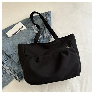 Vue détaillée du grand sac cabas noir en nylon avec design plissé et zip métallique argent