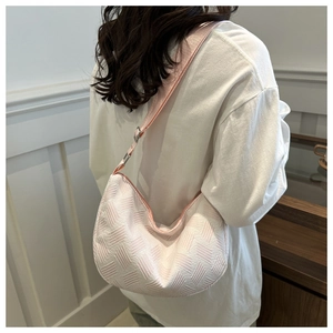 Detail of pink and white woven texture on a crescent nylon shoulder bag with strap