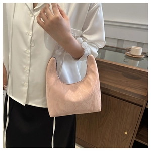 Close-up of pink crescent bag with marble texture fabric and white pearl bead handle