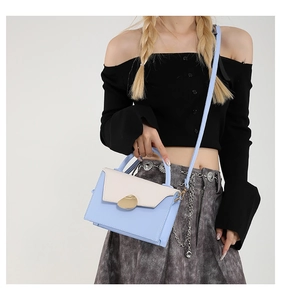 Détail du sac bandoulière bicolore avec boucle en métal doré et fine lanière