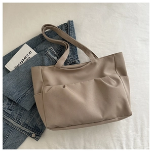 Détail du sac fourre-tout en toile kaki avec grande poche avant plissée et poches de côté