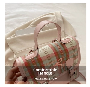 Detailed close-up of the comfortable pink plaid handbag handle and metallic buckle