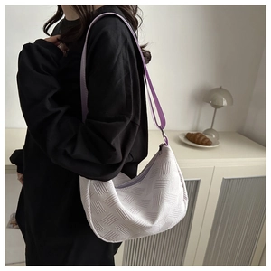 Detail of lavender nylon dumpling bag with textured woven pattern and adjustable strap