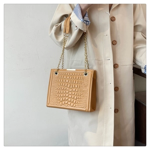 Detail of vintage crossbody bag showing ginger crocodile pattern and gold chain strap