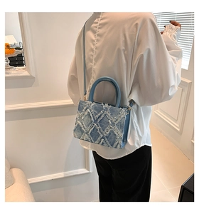 Nahaufnahme der hellblauen Denim-Umhängetasche mit Fransen-Rautenmuster und Gold-Hardware