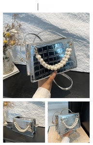 Detail of silver crocodile-embossed mini bag with elegant double pearl beaded handle