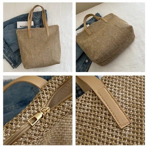 Dettagli della borsa tote in paglia beige con manici marroni e chiusura a zip