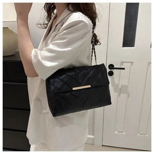 Detail of black quilted leather shoulder bag with V-stitch and gold chain strap