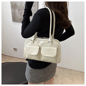 Detailansicht der cremeweißen Tragetasche mit doppelten Klapptaschen und langen Trägern