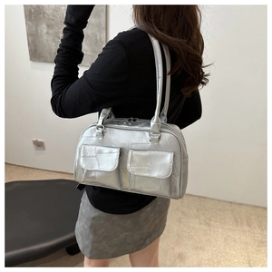 Seitenansicht der silbernen Metallic-Achseltasche mit Pattentaschen und schmalen Riemen
