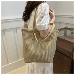 Dettaglio della borsa tote da spiaggia intrecciata con spalline in pelle beige