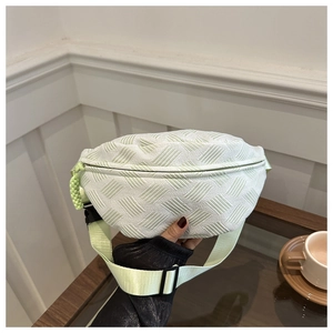 Detalle del bolso bandolera verde menta con textura tejida y correa de nailon ajustable