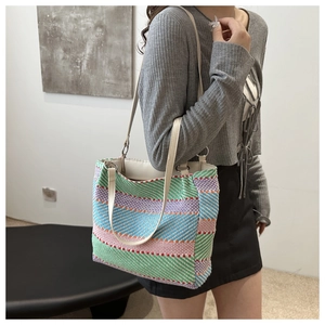 Detail of colorful striped woven canvas tote bag with slim cream leather handles