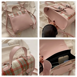 Detail view of pink plaid backpack showing metal buckle, handle and interior storage space