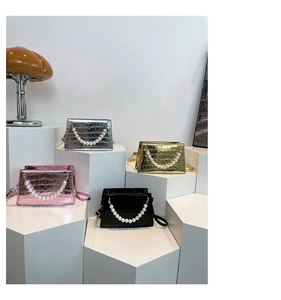 Mini croc-effect handbags in silver, gold, pink, and black with pearl chain handles