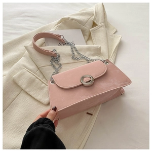 Détail du sac à bandoulière rose avec boucle en métal argenté et bandoulière en chaîne